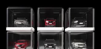 Seis carros. Cada um deles estando dentro de uma proteção de vidro.