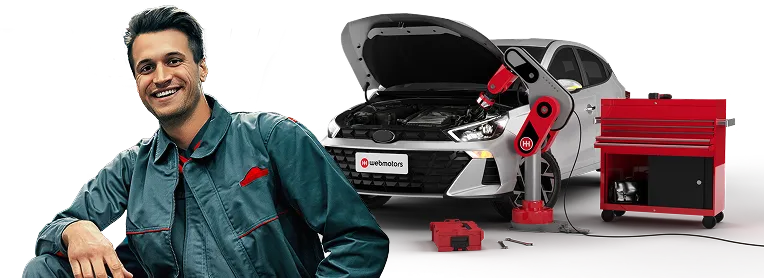 Homem representando o profissional mecânico automotivo na frente de um carro cinza de capo aberto com placa escrito Webmotors.