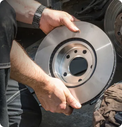 Prestador de serviço realizando o serviço automotivo de troca de disco de freio.