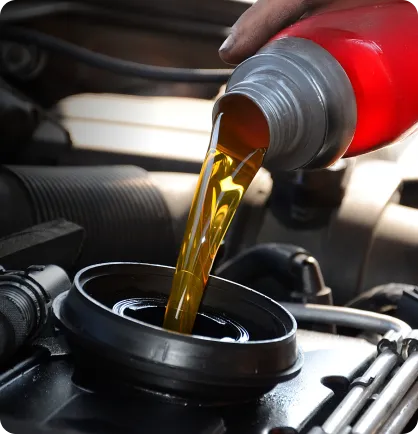 Óleo novo sendo colocado no motor de um carro através de um funil durante a realização do serviço automotivo de troca de óleo.