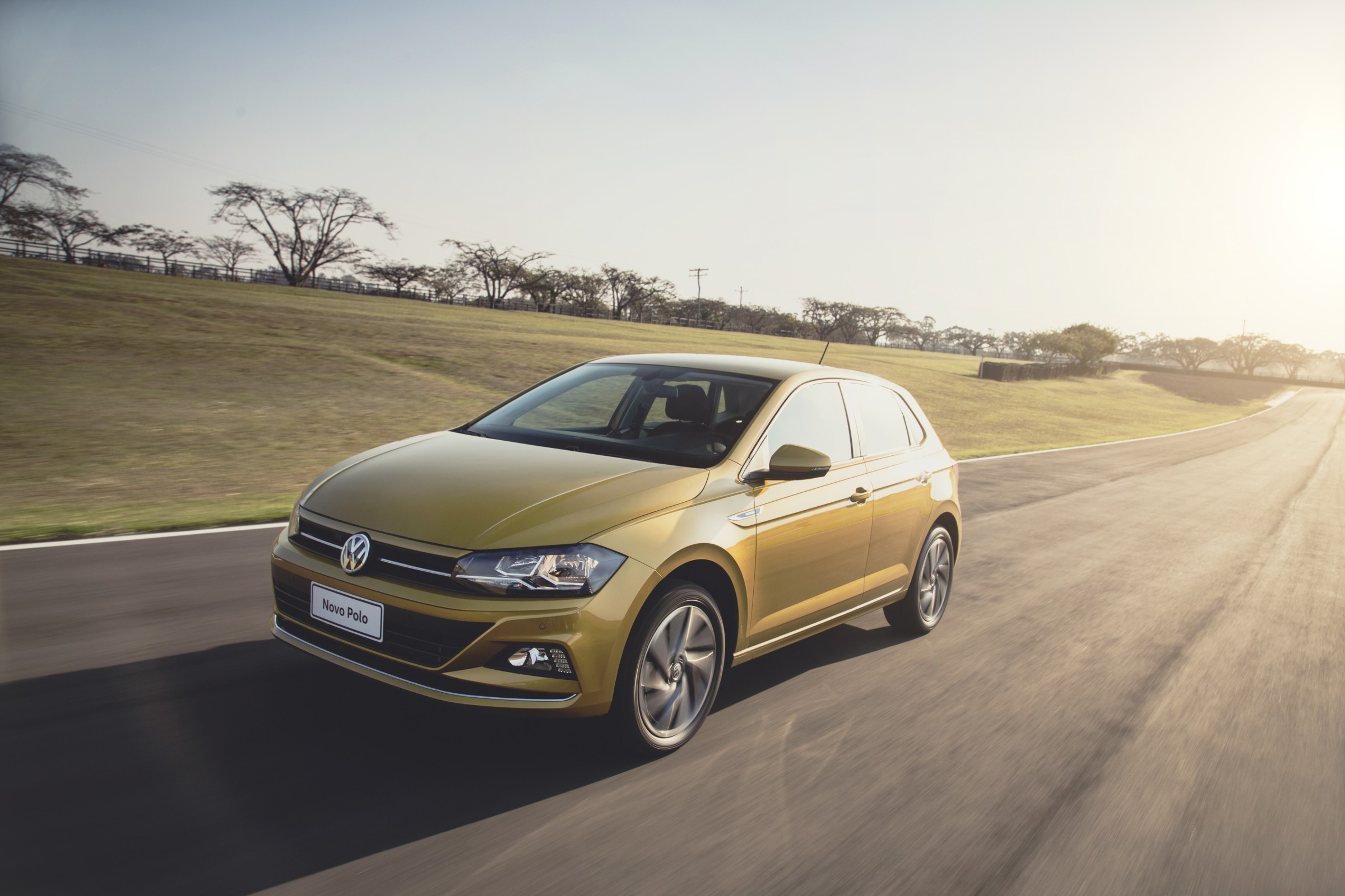 Novo Volkswagen Polo 2018 dourado de frente em movimento na pista com sua frente com elementos horizontais
