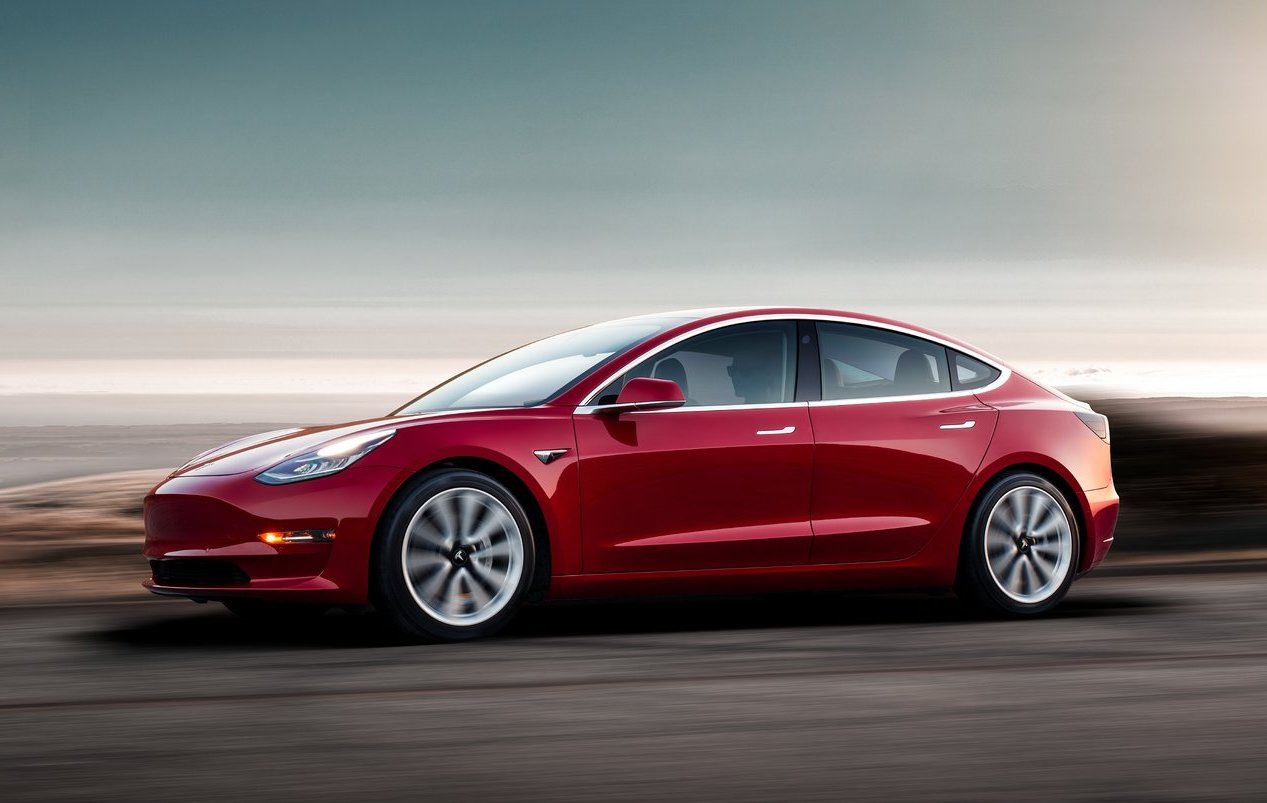 Tesla Model 3 vermelho parado de perfil