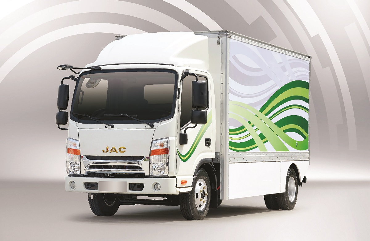iEV 1200T é um caminhão branco com faróis verticais e retangulares e o o baú pintado com ondas verdes
