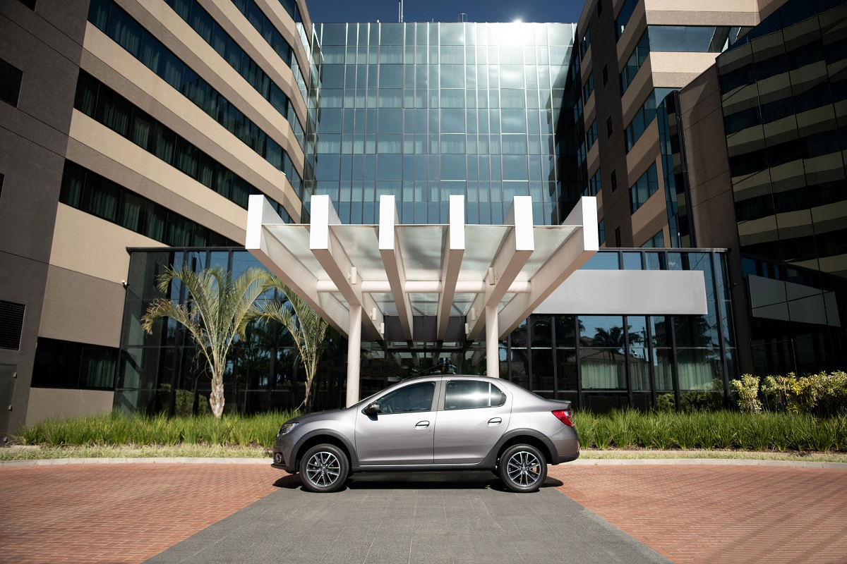 Renault Logan de perfil em frente à portaria de um hotel na versão CVT com molduras nas caixas de rodas