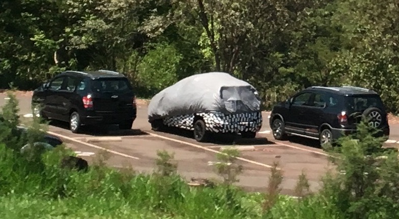 Chevrolet Spin coberta e camuflada de traseira em um estacionamento