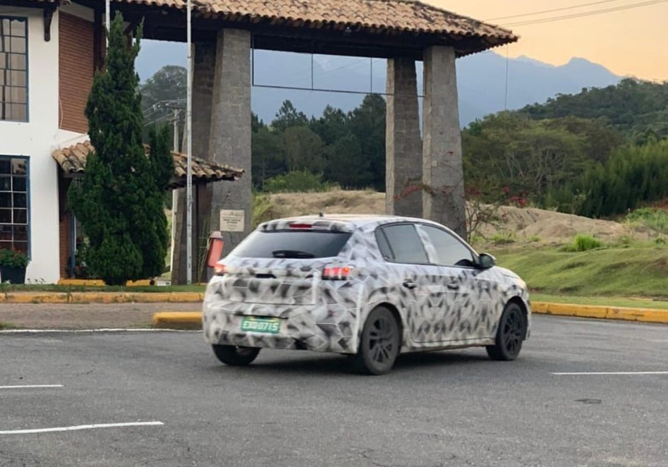 Novo Peugeot 208 camuflado em movimento visto de traseira 3/4
