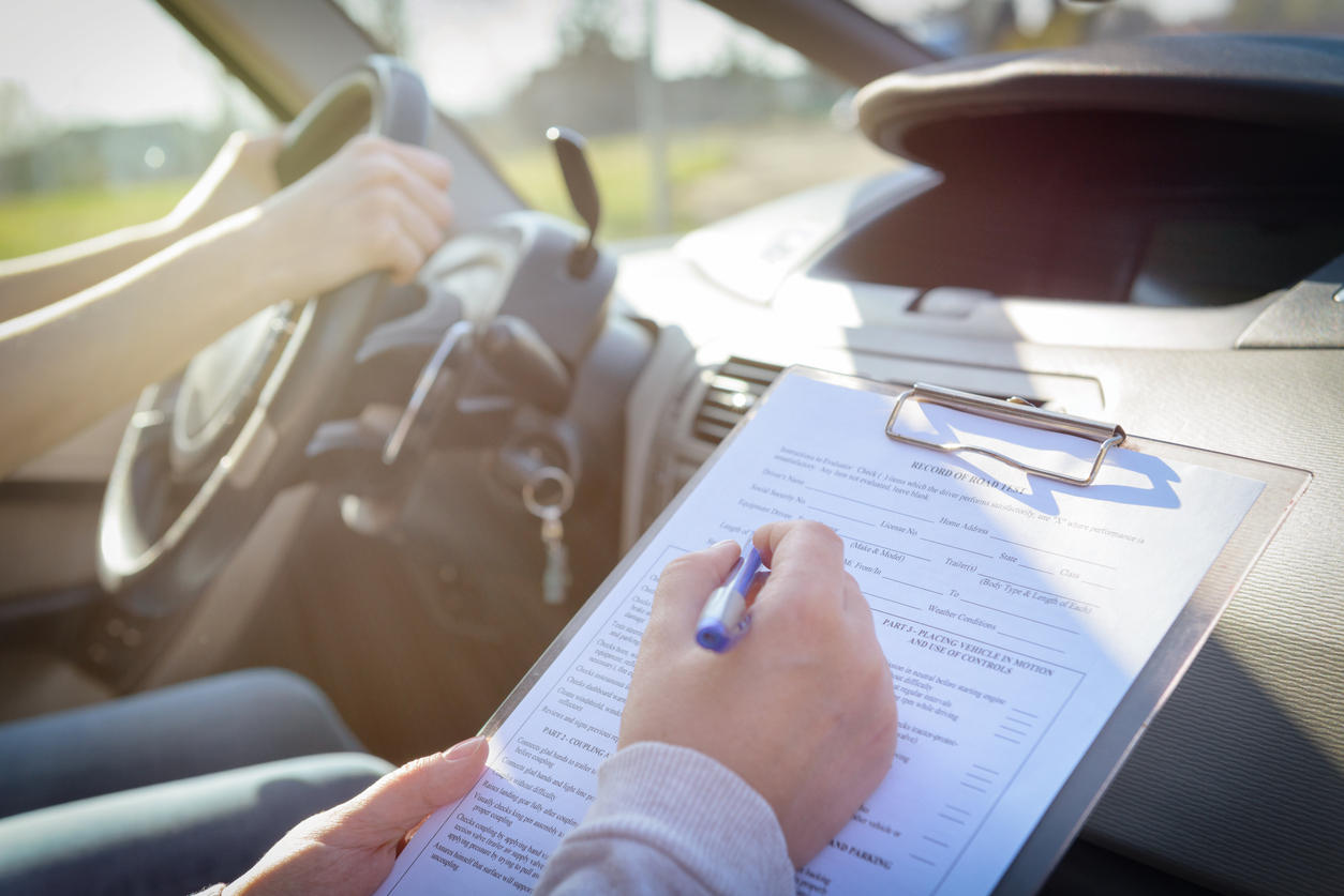 Instrutor preenche formulário de avaliação de motorista candidato a tirar a carteira de habilitação