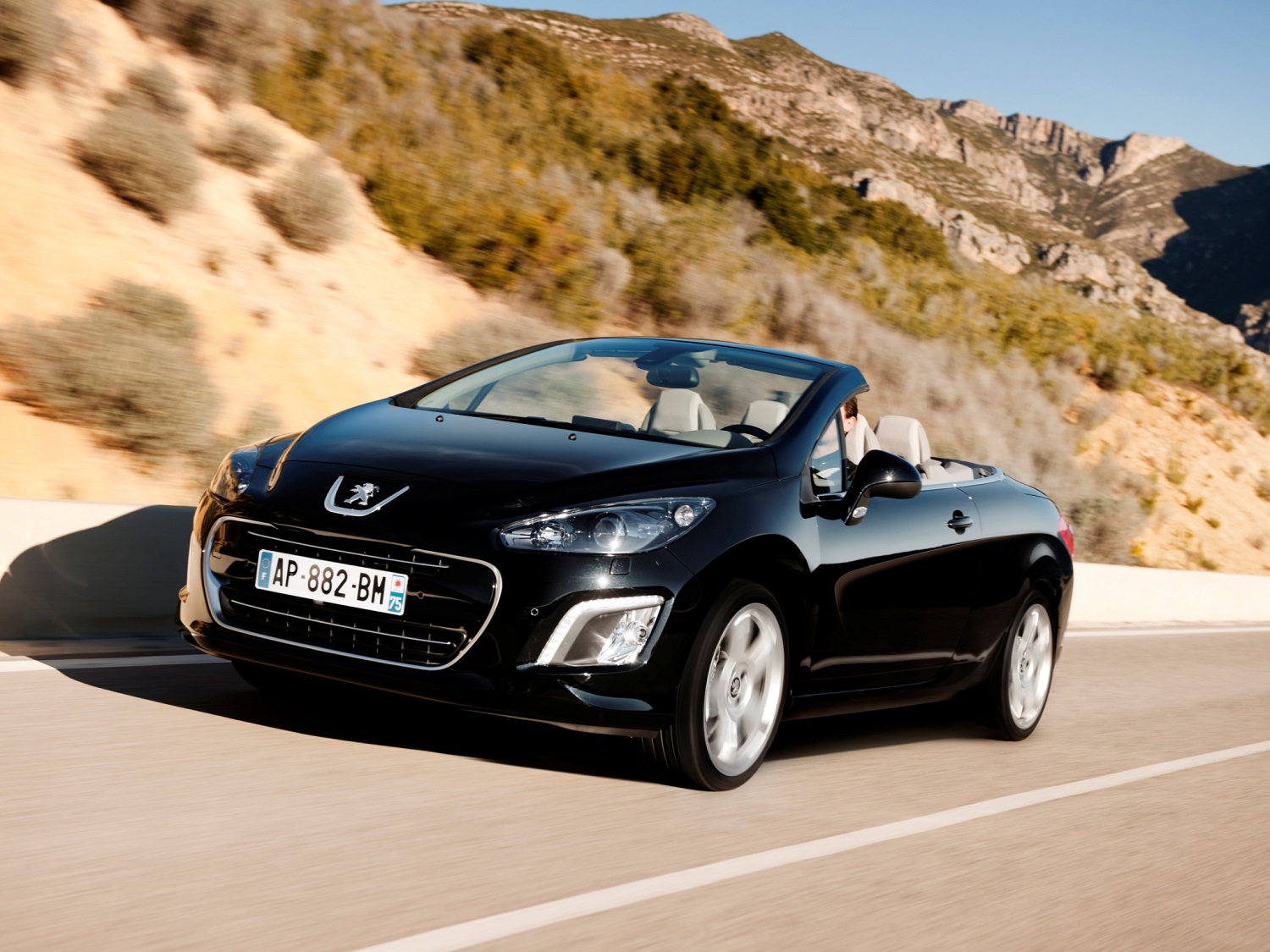 Peugeot 308 coupé cabriolet com a capota aberta e em movimento