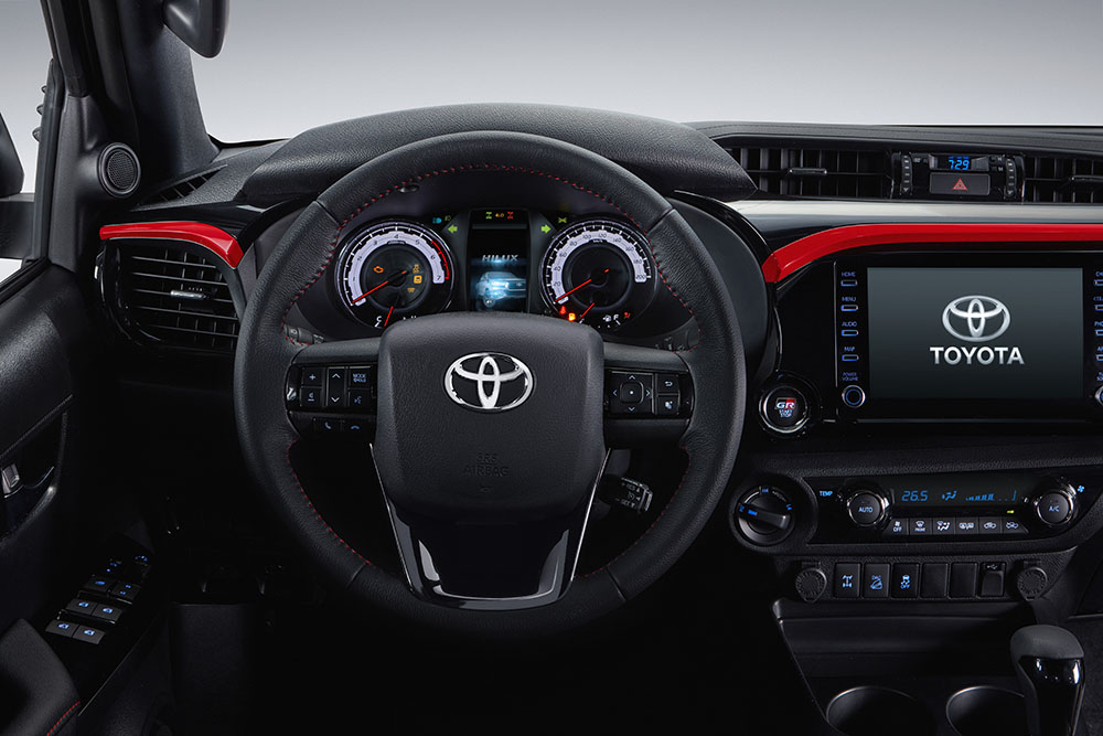 O painel da Hilux V6 tem detalhes vermelhos no painel sobre as saídas de ar e sobre a central multimídia