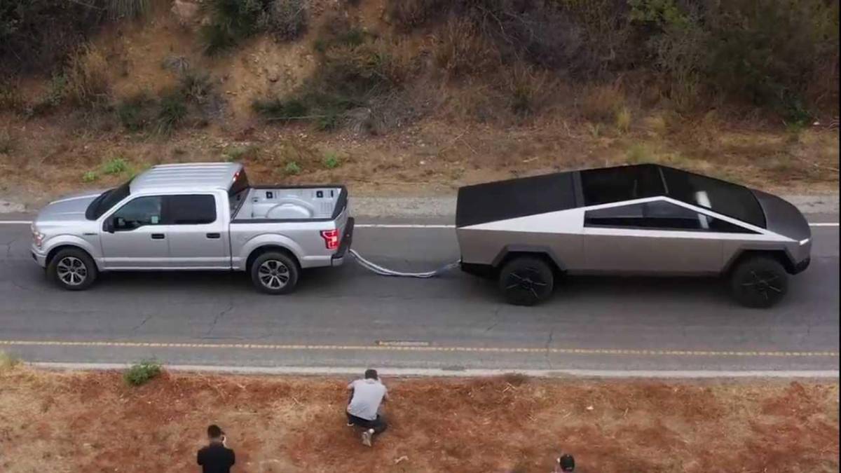 Foto do alto mostra, à esquetrda, a F-150 e, à direita, a picape esquisita da Tesla unidas por um cabo presos aos reboques traseiros