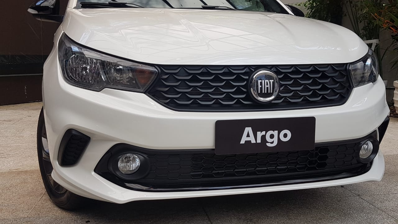 Detalhe dos faróis e da grade do Argo branco com a logomarca da Fiat escurecida