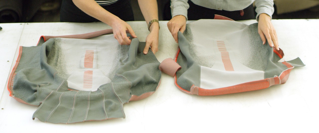 Funcionários manipulam tecido de banco sem costura confeccionado em 3D