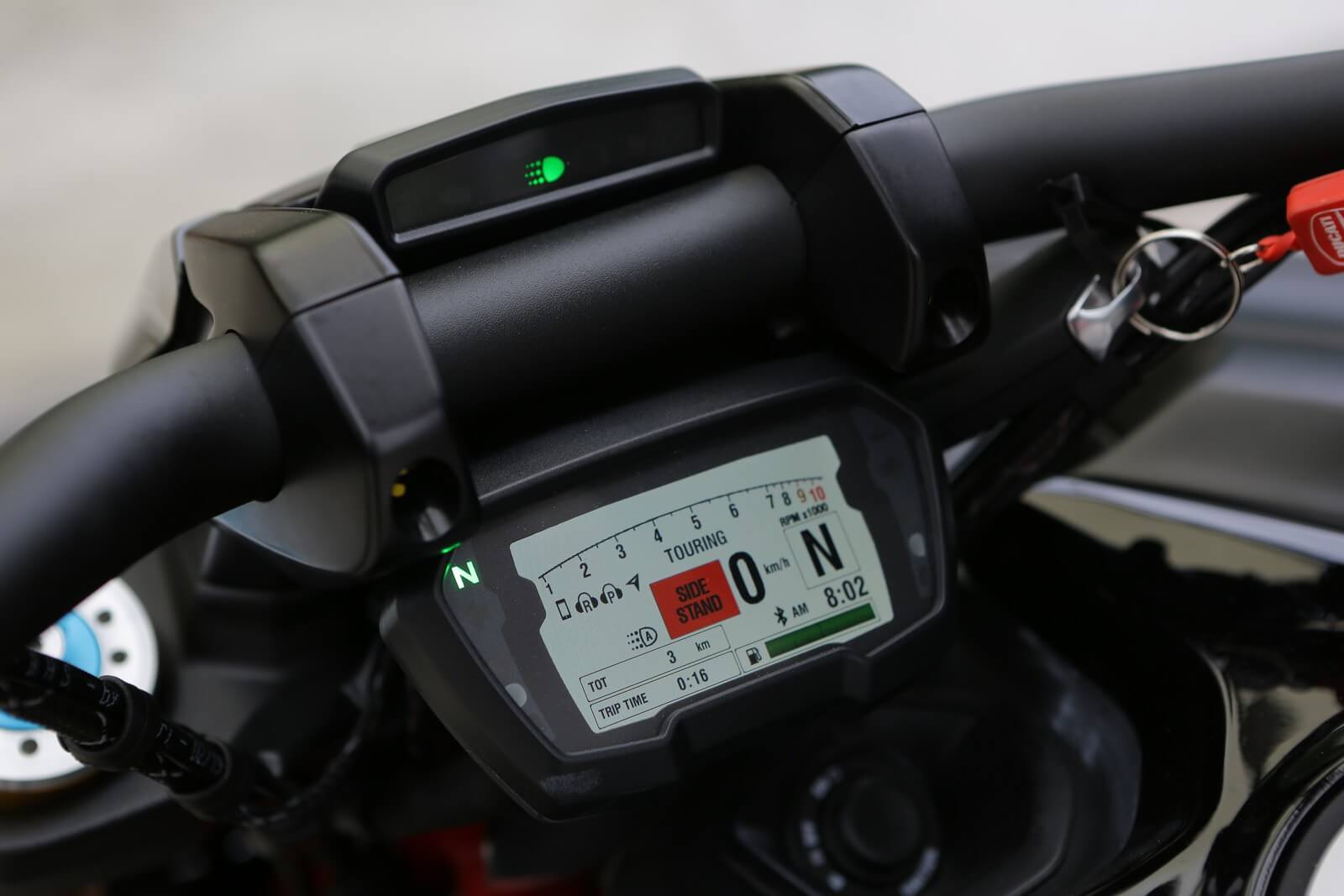 Detalhe do painel digital da Ducati Diavel 1260 com tela de fundo claro, linha de conta-giros, velocímetro e ndicador da marcha