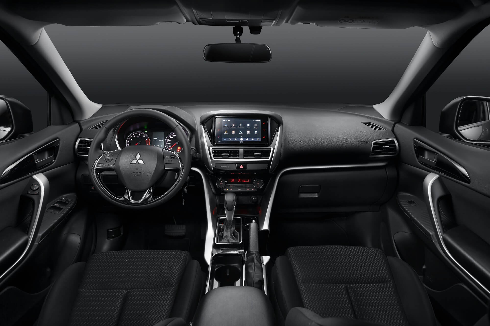 Foto do painel frontal do Eclipse Cross GLS mostra central multimídia, molduras metálicas que vão do painel até a o console central e detalhes em preto brilhante