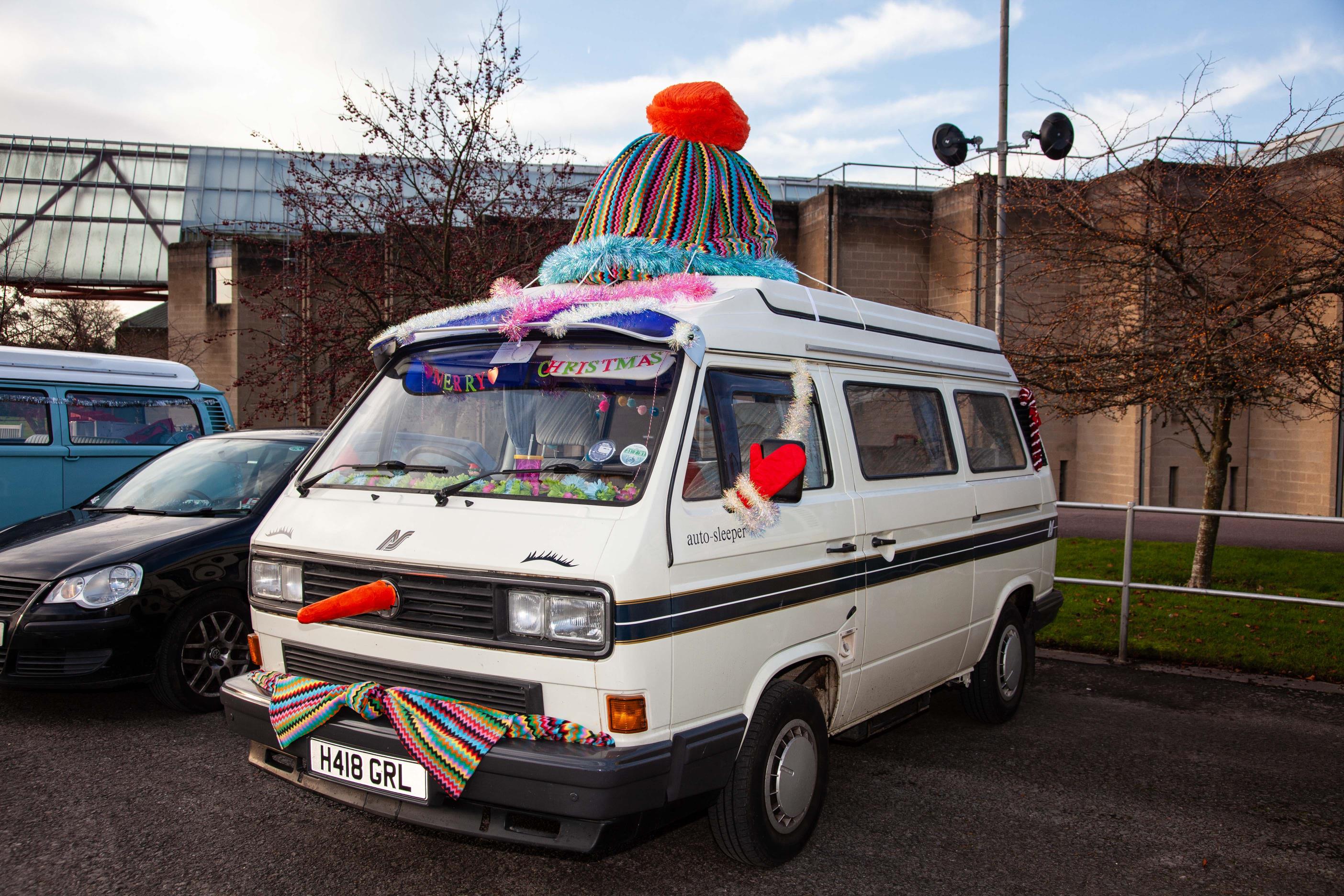 Uma velha Caravelle branca com nariz de cenoura na logo da Volkswagen, luvas próximas ao espelho, cachecol no para-choques e gorro no teto