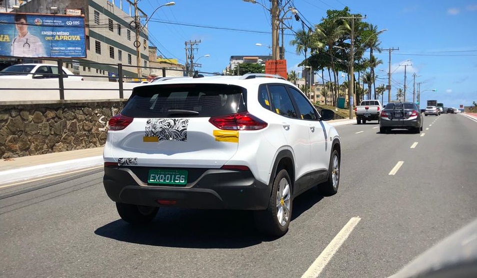Flagra do novo Tracker branco de traseira com a logomarca da Chevrolet coberta e adesivos amarelos sobre as placas com o nome e versão do carro