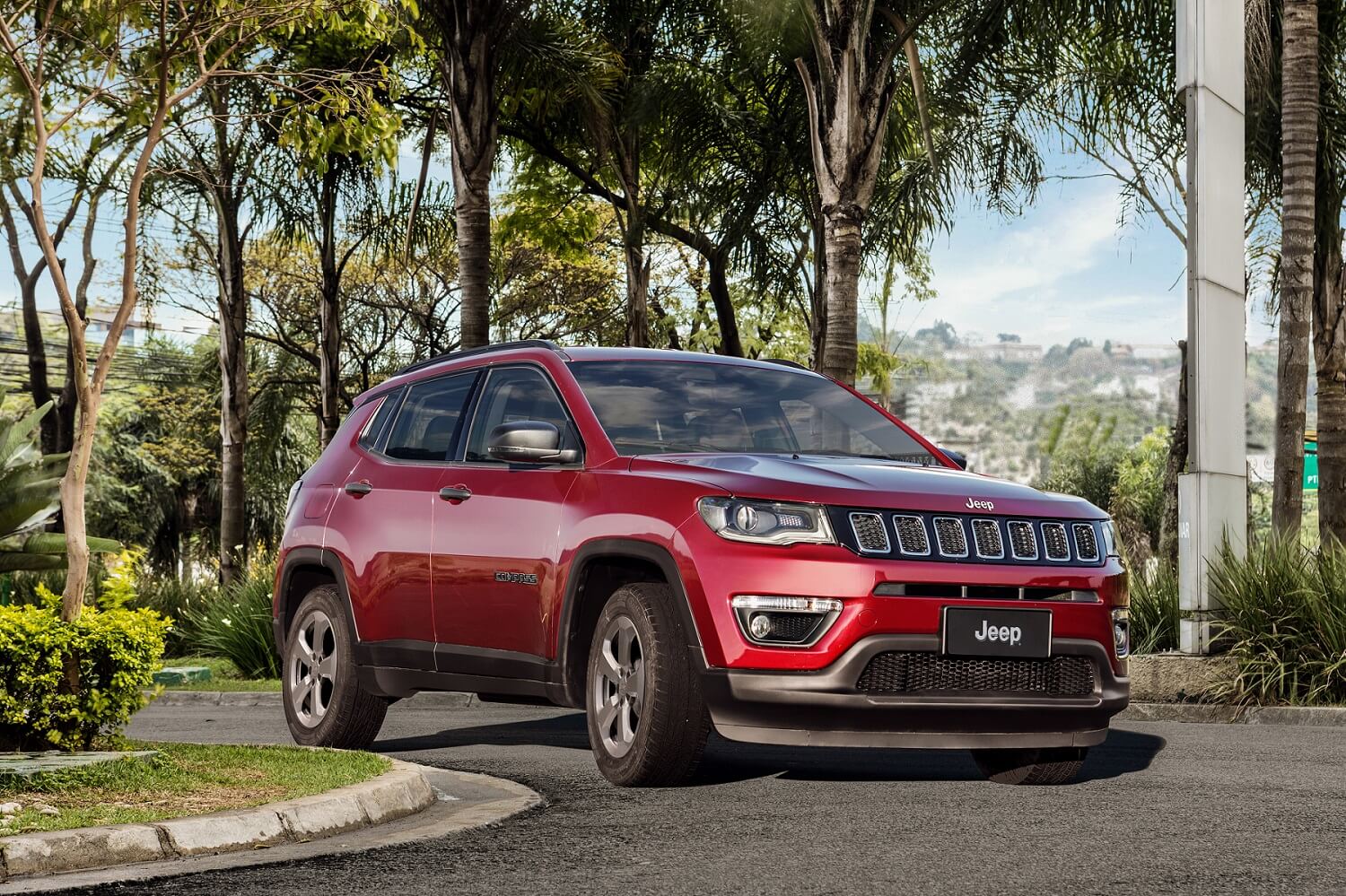 Jeep Compass Sport na cor vinho fazendo a curva em uma rua