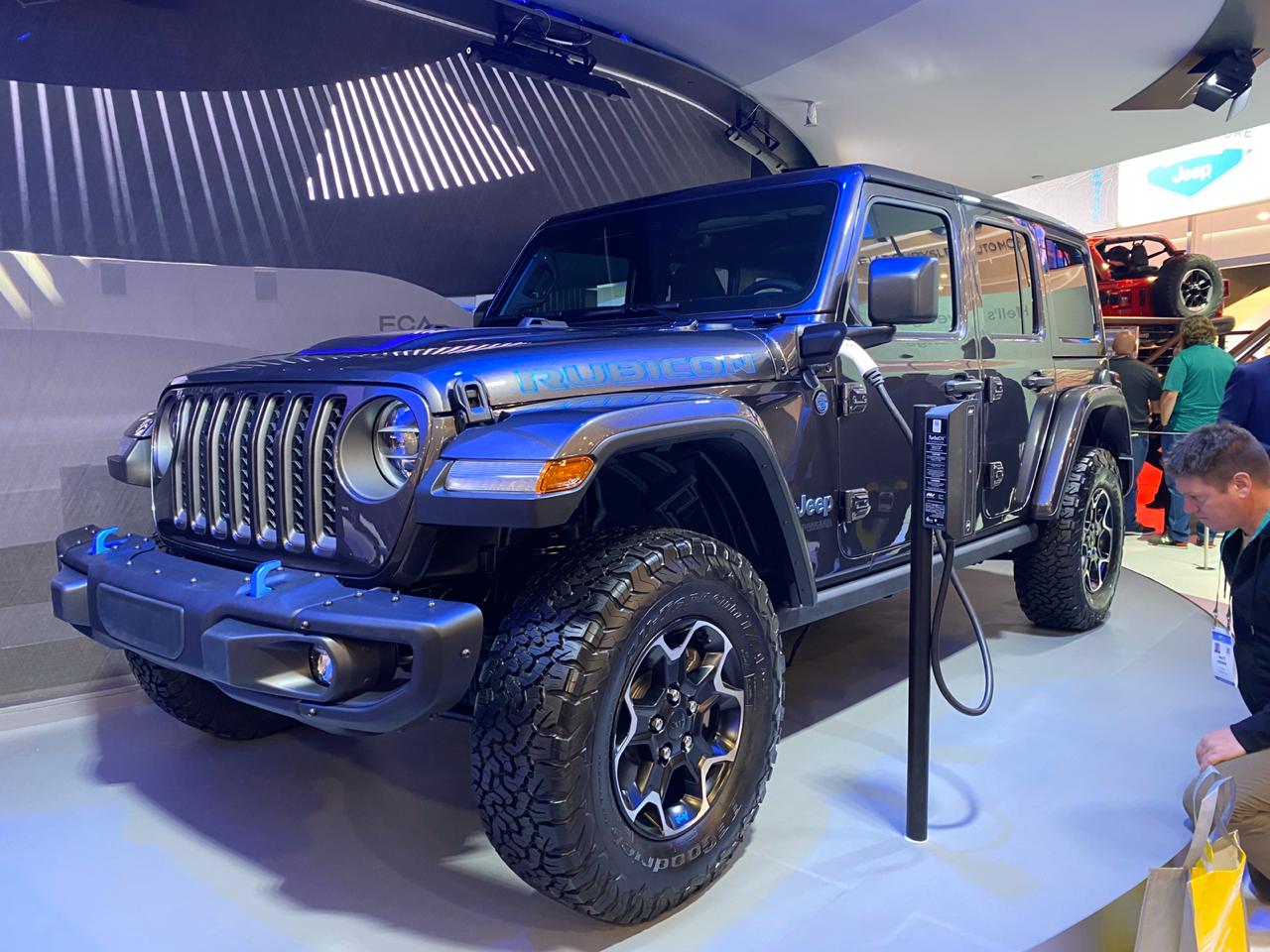 Jeep Wrangler 4xe com mum plugue na tomada próximo ao retrovisor do motorista em exposição no estande da marca na CES