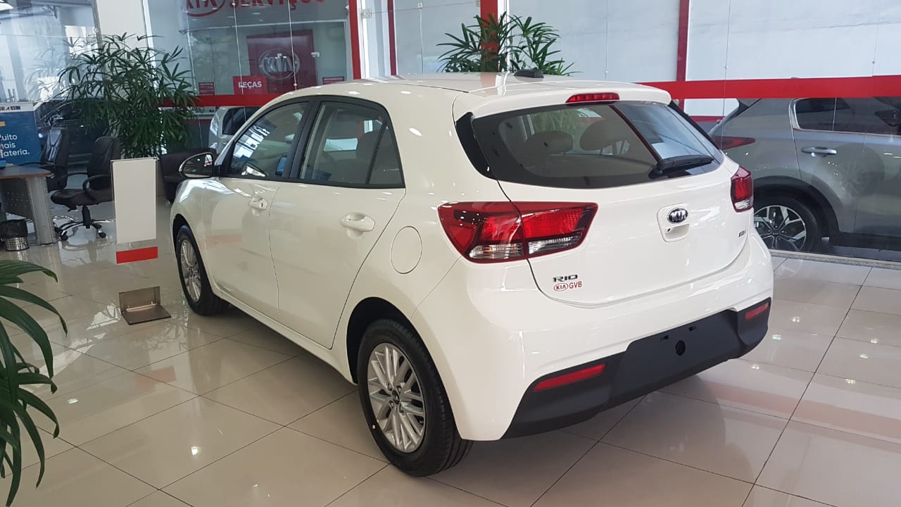 Kia Rio branco de traseira na concessionária com lanternas grandes e horizontalizadas