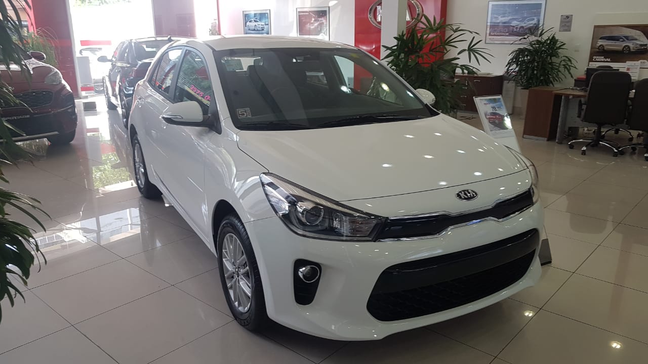 Kia Rio Ex de frente na cor branca com faróis tapezoidis com nichos de luzes diurnas e LEDs dentro
