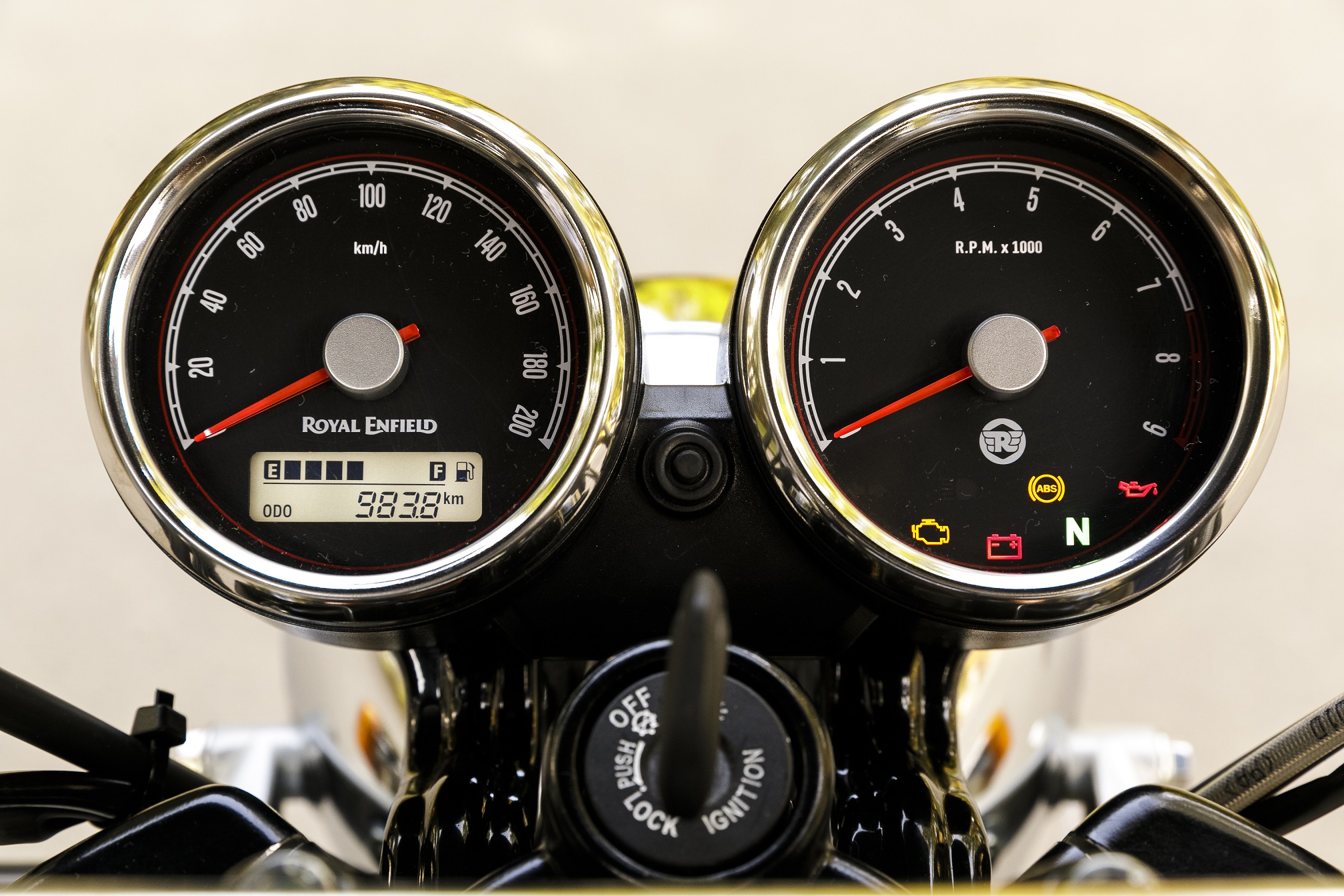 Instrumentos da Royal Enfield Interceptor em mostradores redondos: à esquerda velocímetro em ponteiro com pequena tela TFT retangular com nível de combustível e odômetro