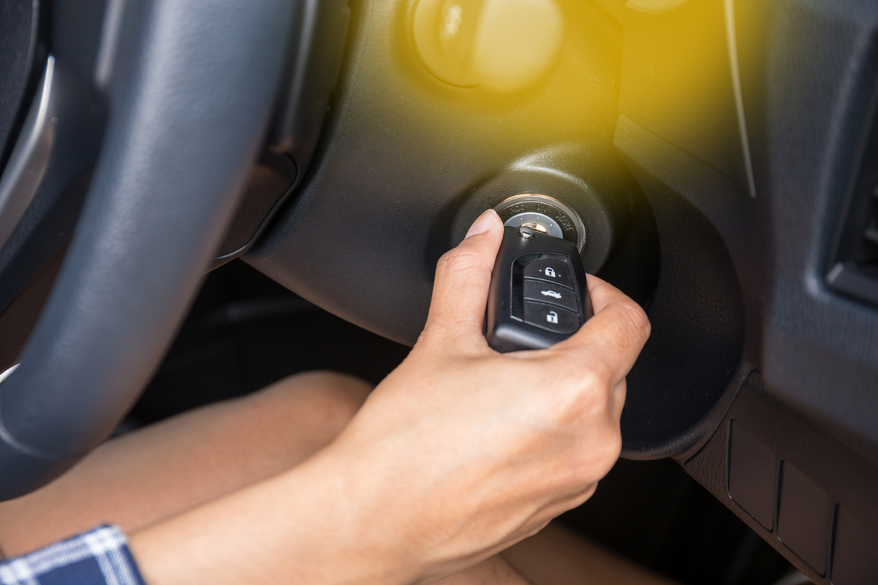 Mão de mulher aparece virando a chave para ligar o motor