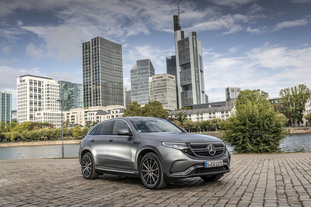 Mercedes Benz EQC cinza de frente na rua ao fundo prédios gigantescos de Frankfurt