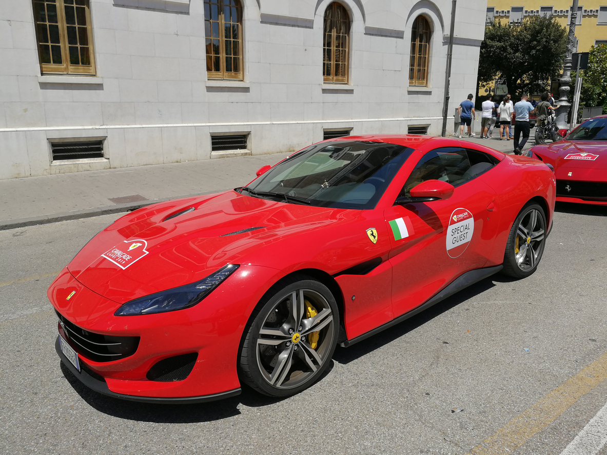 Ferrari Portofino vermelha vista na diagonal e ambientada em um cenário urbano europeu