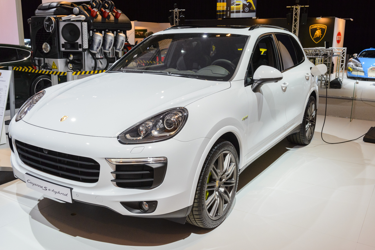 Porsche Cayenne híbrido branco visto de diagonal em salão
