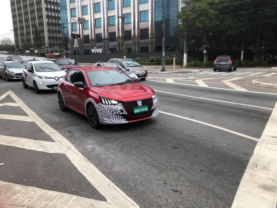 Peugeot 208 vermelho com adesivos de camufçagem na grade e nas extremidades do para-choques