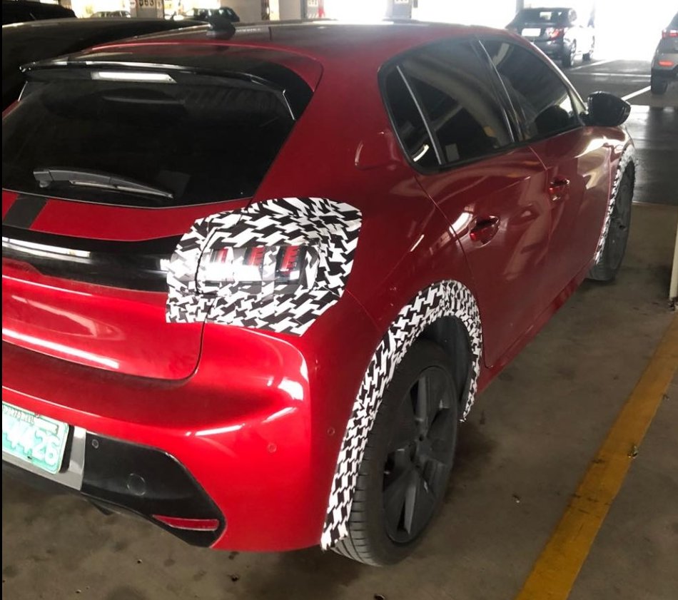 Peugeot 208 vermelho com camuflagem na lanterna traseira e no para-lama
