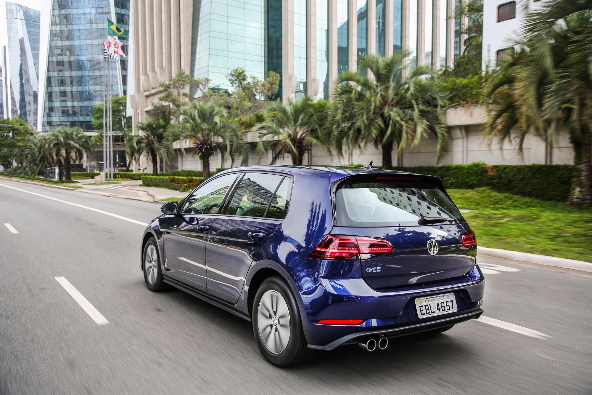 Volkswagen Golf Gte na cor azul em movimento de traseira com lanternas que invadem o porta-malas e ponteira dupla de escapamento