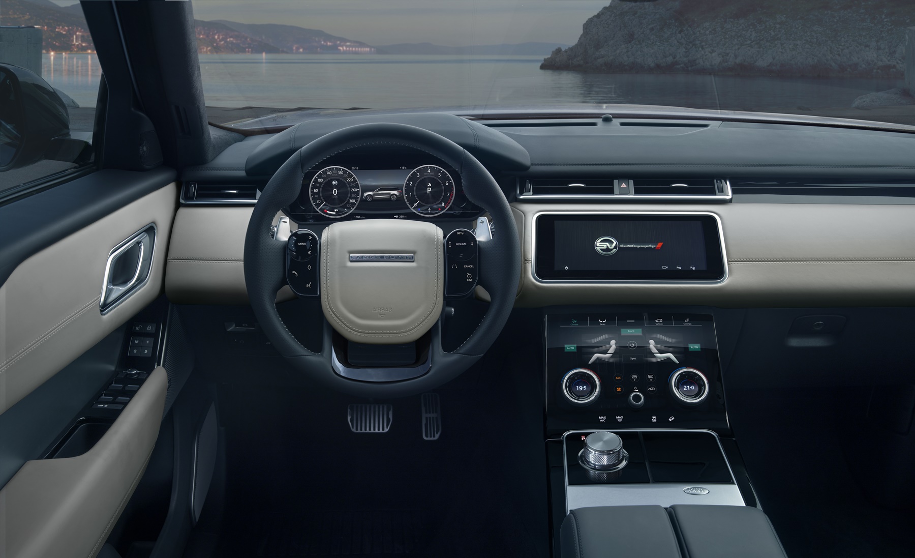 Cabine do Range Rover Velar com partes claras de couro no painel e volante esportivo com costuras aparentes
