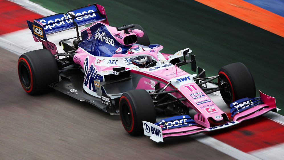 Carro Racing Point rosa passando sobre a zebra da pista em Barcelona