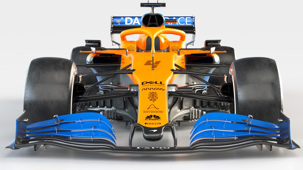Carro de Fórmula 1 da McLaren de frente com pintura amarela e spoiler dianteiro e aerofólio traseiro azuis