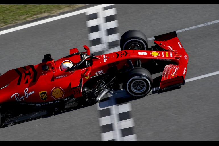 Vista de cima, carro da Ferrari de Fórmula 1 atravessa o grid de largada pintado na pista no circuito de Em Barcelona F1 2020