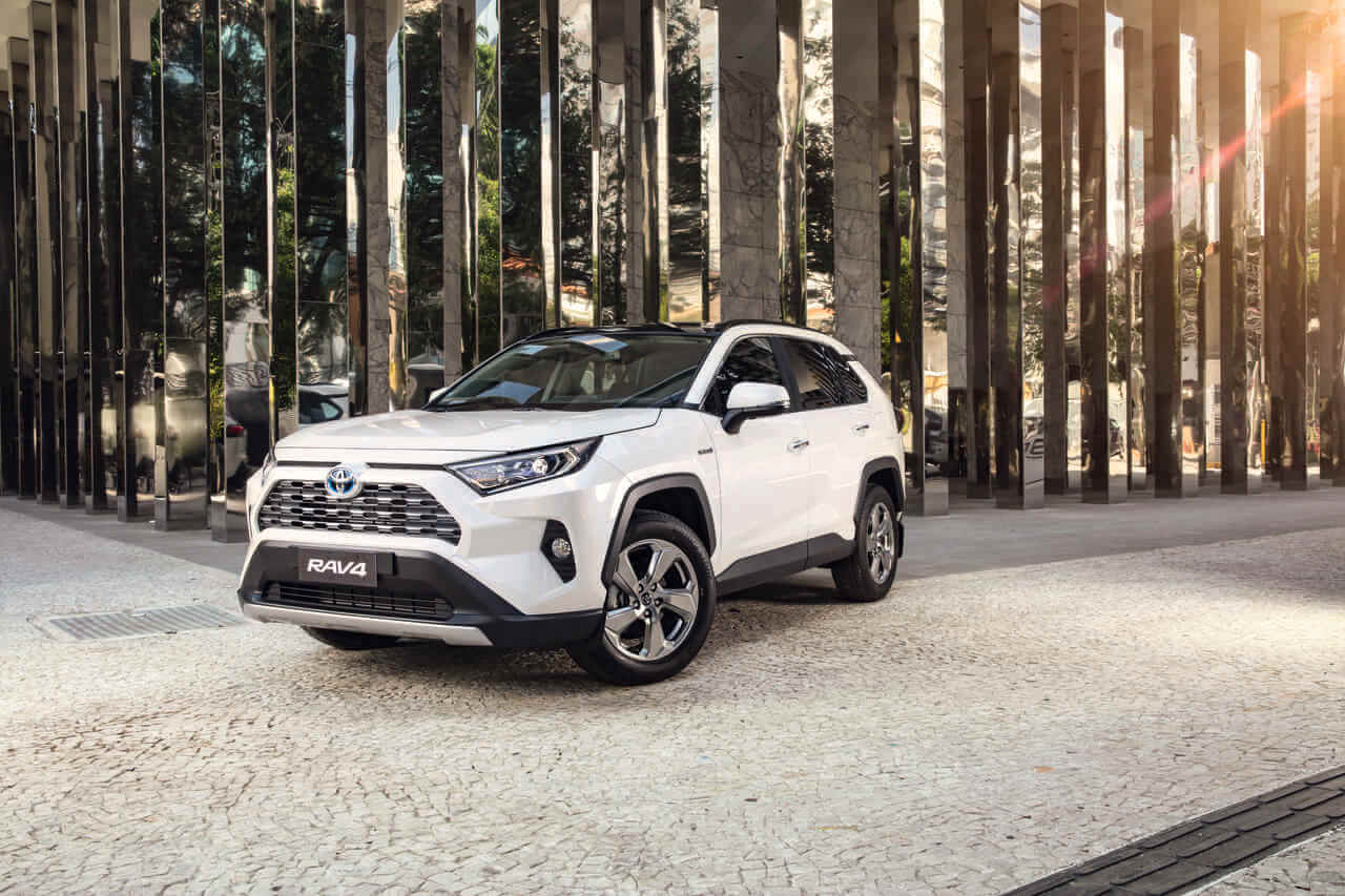 Toyota Rav4 branco de frente tendo ao fundo colunas espelhadas