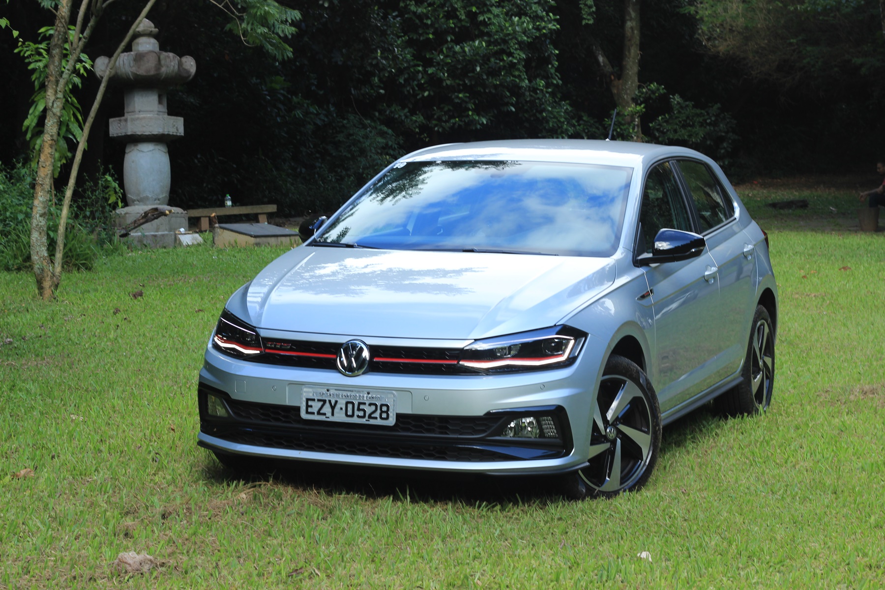 Volkswagen Polo Gts prata de frente em cima de um gramado e com um chafariz ao lado