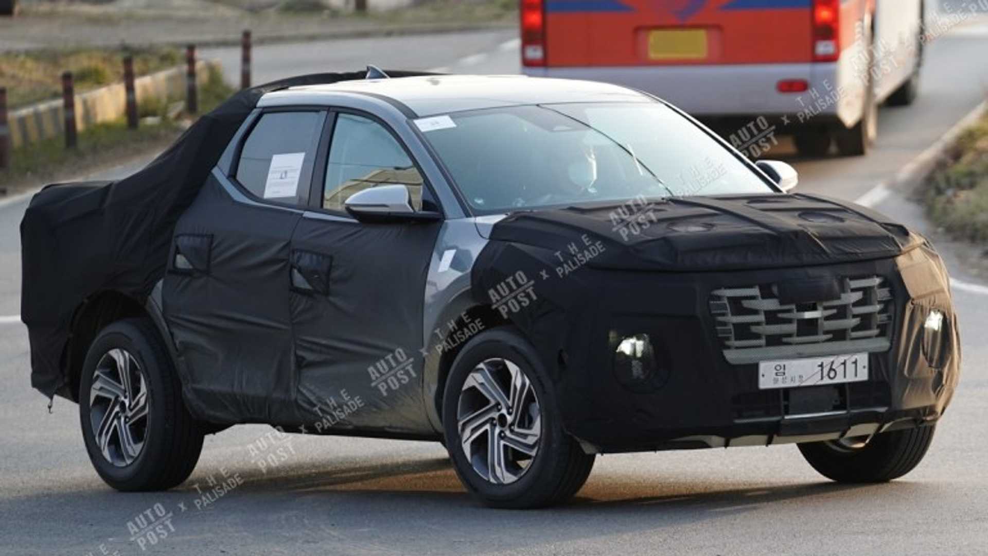 Hyundai Santa Cruz aparece camuflada em movimento com disfarces pretos principalmente na frente cobrindo a grade e para-choques