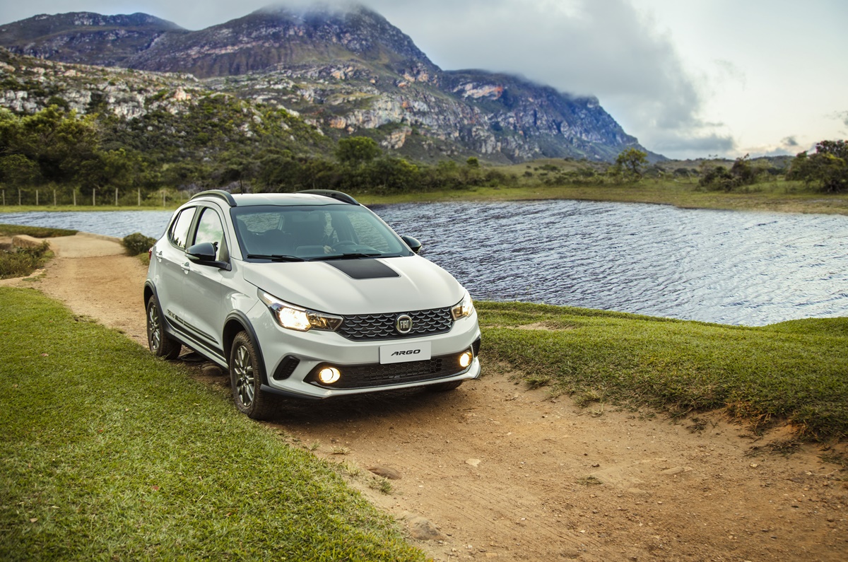 Fiat Argo Trekking branco com detalhes pretos em pequena via de terra com lago ao lado