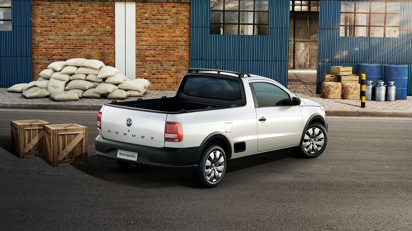 Volkswagen Saveiro Robust cabine simples de traseira vista do alto com galpão ao fundo e uma pilha de sacos de cimento ao lado