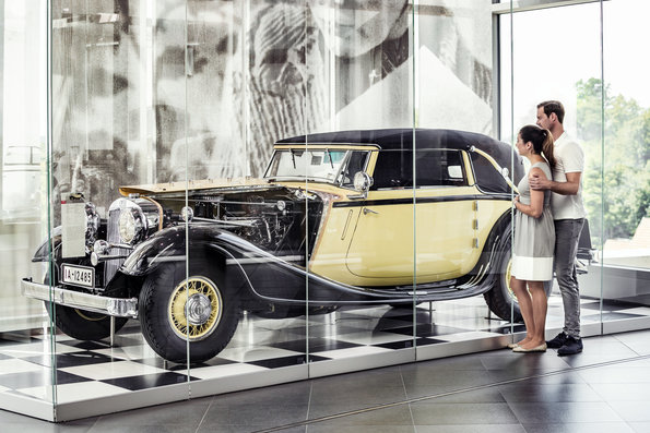 Mulher observa um caro antigo no acervo do Museu da Audi