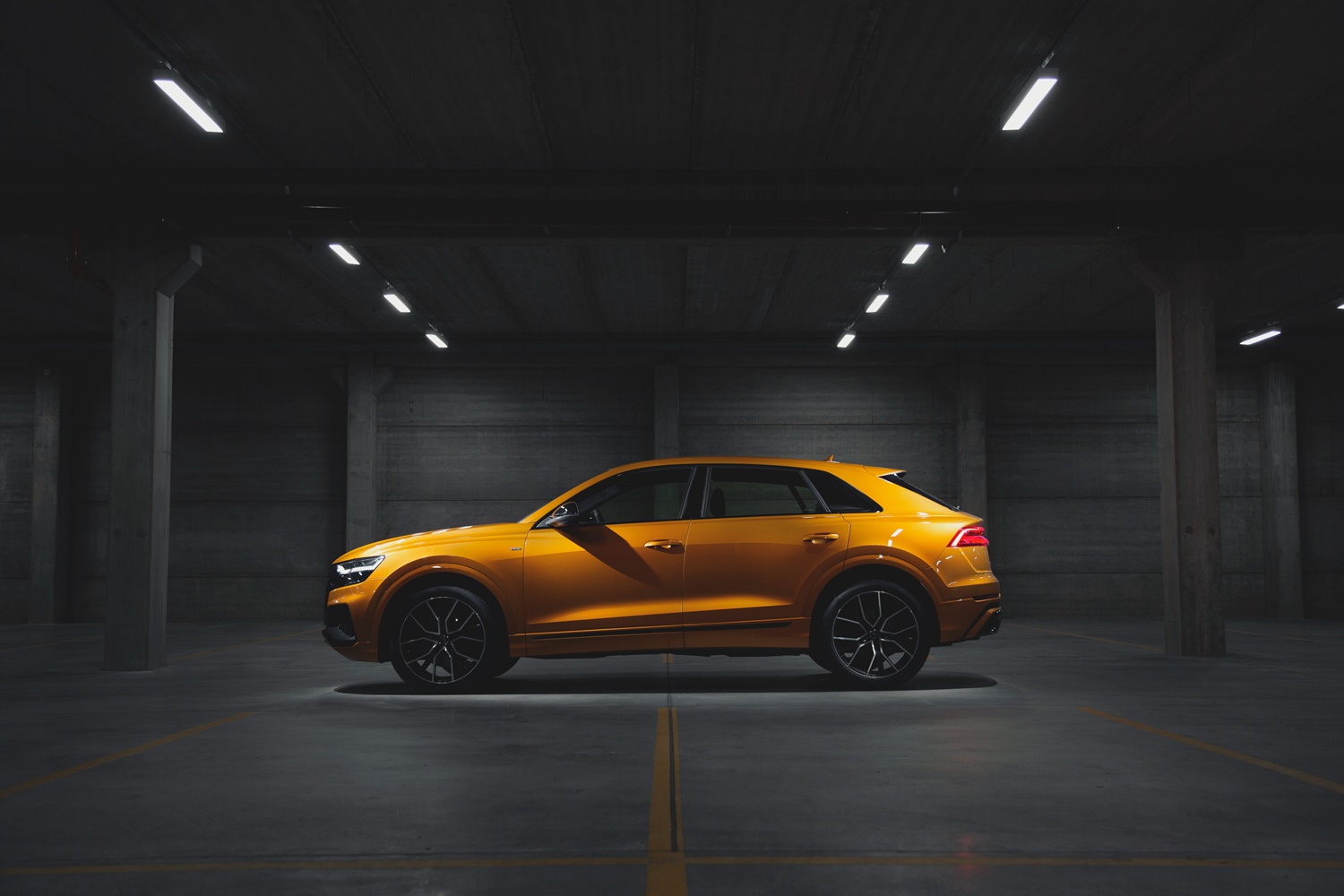 Audi Q8 de perfil no estacionamento na cor doyrado
