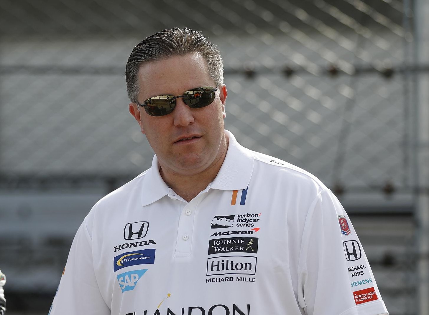 O piloto Fernando Alonso com macacão branco da escuderia McLaren ao lado do diretor da equipe, Zak Brown