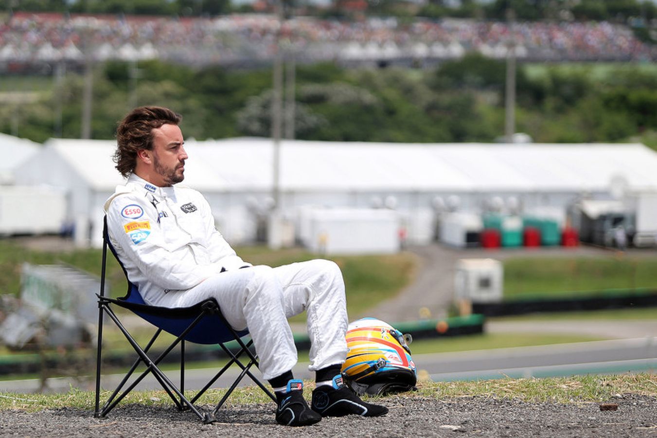 Fernando Alonso sentado em uma cadeira com o,olhar distante durante o treino para o Grande Prêmio do Brasil, ainda pela McLaren