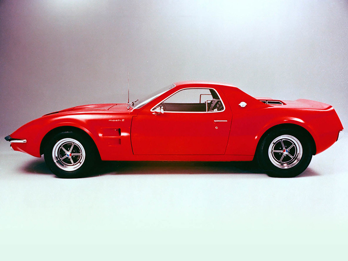 Ford Mustang Mach2 1967 vermelho de perfil com capô longo, rodas grandes e traseira curta