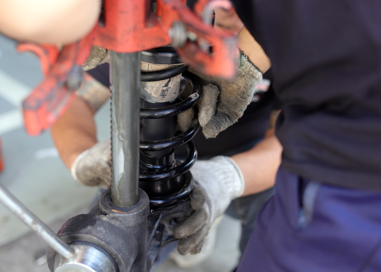 Amortecedor de carro gasto com mecânico fazendo os consertos