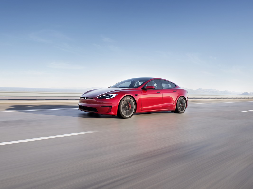 Tesla Model S Plaid vermelho em movimento em estrada
