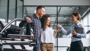 Young Couple Choosing A Car In A Car Show Room