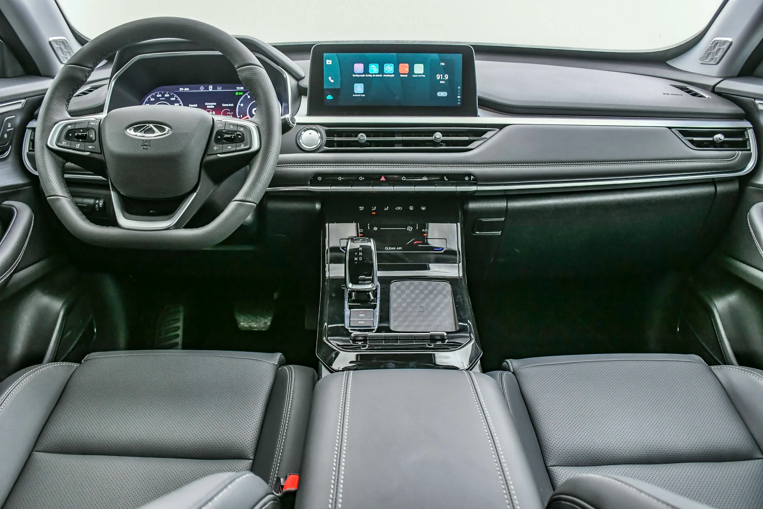 Foto do interior do Caoa Chery Tiggo Sport. Destaques para volante, câmbio e central multimídia.